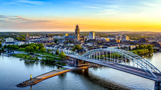 “8K panoramafoto van de iconische John Frostbrug over de Rijn in Arnhem, Nederland, met uitzicht op de historische binnenstad bij zonsondergang – professionele landmarkfoto voor meubels herstofferen en meubelstoffering in Arnhem.”