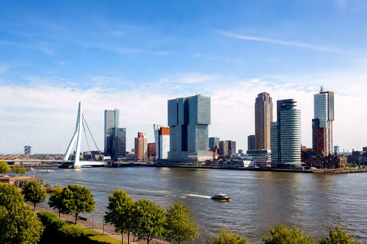 “8K breedbeeldfoto van de moderne skyline van Rotterdam met de iconische Erasmusbrug bij zonsondergang – stijlvolle landmarkfoto voor meubels herstofferen en meubelstoffering in Rotterdam.”